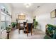 Elegant dining room featuring a glass table, four chairs, decorative plants, and a sunny window at 6436 Longlake Dr, Port Orange, FL 32128