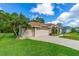 Lovely home features a three-car garage, mature palms, and attractive landscaping at 6436 Longlake Dr, Port Orange, FL 32128