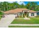Charming single-story home featuring a well-manicured lawn, mature landscaping, and a welcoming front entrance at 6436 Longlake Dr, Port Orange, FL 32128