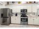 Modern kitchen featuring stainless steel appliances, white cabinets, and tiled backsplash at 6436 Longlake Dr, Port Orange, FL 32128