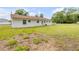 Spacious backyard featuring lush lawn and white siding on house, perfect for outdoor activities at 701 West St, New Smyrna Beach, FL 32168