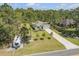 Aerial view of a well-kept property featuring a single-story home, with a long driveway, large lawn, and privacy trees at 703 Volco Rd, Edgewater, FL 32141