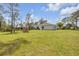 A spacious backyard surrounded by trees and a privacy fence offering a tranquil outdoor retreat at 703 Volco Rd, Edgewater, FL 32141