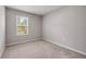 Serene bedroom with soft carpet, neutral walls, and a window with a nature view at 703 Volco Rd, Edgewater, FL 32141