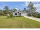 Pleasant single-story home featuring an attached garage, a long driveway, well-maintained lawn, and manicured landscaping at 703 Volco Rd, Edgewater, FL 32141