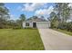 Well-maintained single-story home with an attached garage, a long driveway, well-maintained lawn, and mature landscaping at 703 Volco Rd, Edgewater, FL 32141