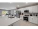 Open-concept kitchen with stainless steel appliances, white cabinets, tile flooring, and easy access to dining area at 703 Volco Rd, Edgewater, FL 32141