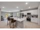 Modern kitchen with stainless steel appliances, white cabinets, a central island, and an adjacent dining area at 703 Volco Rd, Edgewater, FL 32141