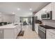 Bright, open kitchen with stainless steel appliances, ample counter space, and a view into the dining area at 703 Volco Rd, Edgewater, FL 32141