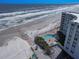 Breathtaking aerial view showcasing a beachfront condo with a sparkling pool and ocean access at 705 N Atlantic Ave # 4030, New Smyrna Beach, FL 32169