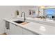 Modern kitchen with stainless steel sink and appliances, white cabinets, and a stunning view of the ocean at 705 N Atlantic Ave # 4030, New Smyrna Beach, FL 32169