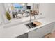 Modern kitchen with stainless steel sink and appliances, white cabinets, and a stunning view of the ocean at 705 N Atlantic Ave # 4030, New Smyrna Beach, FL 32169