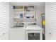 Functional laundry room with full sized washer and dryer and shelving for storage at 705 N Atlantic Ave # 4030, New Smyrna Beach, FL 32169