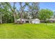 Single-story home with a lush green front lawn and mature trees at 795 Sugar Cane Ln, Port Orange, FL 32129