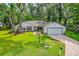 Charming single-story home with an attached garage, brick drive and a well-manicured lawn at 795 Sugar Cane Ln, Port Orange, FL 32129