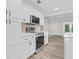 Well-equipped kitchen with stainless steel range, white cabinets, and seamless flow to the living area at 795 Sugar Cane Ln, Port Orange, FL 32129