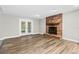 Inviting living room featuring hardwood floors and a cozy brick fireplace, perfect for relaxing at 795 Sugar Cane Ln, Port Orange, FL 32129