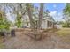 Landscaped backyard with patio area, mature trees, and cozy seating for relaxing outdoor living at 801 Canal St, New Smyrna Beach, FL 32168