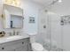 Updated bathroom with shower, stylish mosaic tile floor, and granite countertop at 801 Canal St, New Smyrna Beach, FL 32168