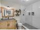 Modern bathroom with a stand-up glass shower, stone tile floors, and floating wooden shelves at 801 Canal St, New Smyrna Beach, FL 32168