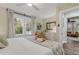 Bedroom with wood-look floors, many windows, neutral walls, and a glimpse into the living room at 801 Canal St, New Smyrna Beach, FL 32168