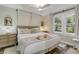 Bright bedroom featuring wood-look floors, a ceiling fan, a tufted headboard, and many windows at 801 Canal St, New Smyrna Beach, FL 32168