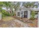 Exterior of a cottage-style home with white siding, a metal roof, and mature landscaping at 801 Canal St, New Smyrna Beach, FL 32168