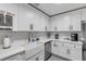 Well-lit kitchen featuring white cabinets, stainless steel dishwasher, and farm sink at 801 Canal St, New Smyrna Beach, FL 32168
