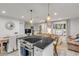 Bright kitchen with island cooktop, wicker bar stools, and an open design into the dining and living areas at 801 Canal St, New Smyrna Beach, FL 32168