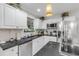 Bright kitchen with white cabinets, stainless steel appliances, and black countertops at 801 Canal St, New Smyrna Beach, FL 32168