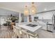 Bright, open kitchen features white cabinets, a center island with bar seating, and pendant lighting at 801 Canal St, New Smyrna Beach, FL 32168