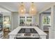 A kitchen island with cooktop is displayed with a view of windows and eat in seating at 801 Canal St, New Smyrna Beach, FL 32168