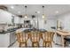 Open kitchen featuring white cabinets, stainless steel appliances, a large island, and wicker bar stools at 801 Canal St, New Smyrna Beach, FL 32168