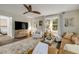 Cozy living room featuring wood floors, a ceiling fan, and bright natural light from the windows at 801 Canal St, New Smyrna Beach, FL 32168