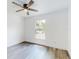 Bright bedroom features a ceiling fan, a window with a yard view, and wood grain flooring at 808 Rosalia Dr, Sanford, FL 32771