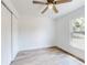 Bright bedroom features a ceiling fan, a window, wood grain flooring and a closet at 808 Rosalia Dr, Sanford, FL 32771