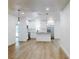 Open living area with hardwood floors, custom shelving, mini fridge, recessed lighting and view of the kitchen at 808 Rosalia Dr, Sanford, FL 32771