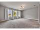 Bedroom featuring three windows, carpet, and statement chandelier at 1100 Loch Linnhe Ct, New Smyrna Beach, FL 32168
