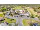 Aerial view of a clubhouse surrounded by palm trees with a parking lot and golf course in the background at 1100 Loch Linnhe Ct, New Smyrna Beach, FL 32168
