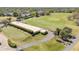 Aerial view of a golf course with putting greens and a building with manicured hedges at 1100 Loch Linnhe Ct, New Smyrna Beach, FL 32168