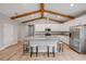 Bright kitchen features white cabinets, stainless steel appliances, large island, and wooden beam ceiling at 1100 Loch Linnhe Ct, New Smyrna Beach, FL 32168