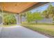 Covered patio with a wood plank ceiling and landscaped backyard at 1100 Loch Linnhe Ct, New Smyrna Beach, FL 32168