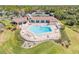 Aerial view of a community pool and tennis courts with lounge chairs on a sunny day at 1100 Loch Linnhe Ct, New Smyrna Beach, FL 32168