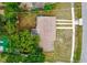 Aerial view of home surrounded by lush greenery and features a driveway leading to the street at 1364 W Hartley Cir, Deltona, FL 32725