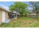 Spacious backyard featuring the home, the screened in porch, mature trees and partial fencing at 1364 W Hartley Cir, Deltona, FL 32725