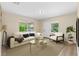 Bright living room with hardwood floors, large windows, neutral walls, a cream colored sofa, and stylish modern décor at 1364 W Hartley Cir, Deltona, FL 32725