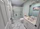 Bright bathroom featuring marble floors, a shower, and a framed mirror at 2530 Tamarind Dr, Edgewater, FL 32141