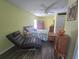 Well-lit bedroom with hardwood floors, a ceiling fan, and a lounge chair at 2530 Tamarind Dr, Edgewater, FL 32141