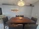 Elegant dining room with a large dark wood table, seating for six, and a decorative chandelier at 2530 Tamarind Dr, Edgewater, FL 32141