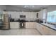 Well-lit kitchen featuring stainless steel appliances, white cabinetry, and tile flooring at 2530 Tamarind Dr, Edgewater, FL 32141